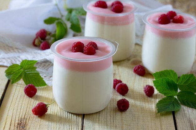 Yogur casero con frambuesas en una mesa de madera