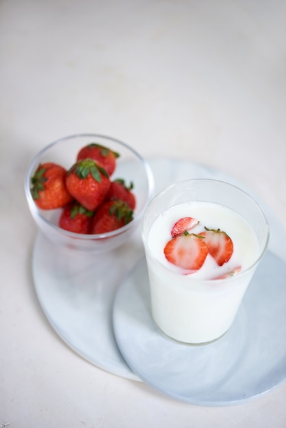 Yogur casero de fresa con fresas frescas en el cuadro blanco