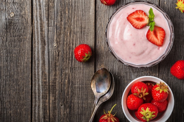 Foto yogur casero con fresa fresca en madera