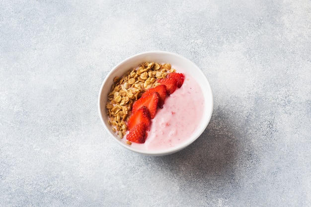 Yogur casero con fresas frescas y muesli. El concepto de un desayuno saludable. Copia espacio