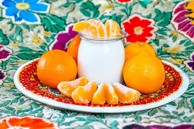 Foto yogur casero con una mandarina para el desayuno comida saludable, dietética y vegana