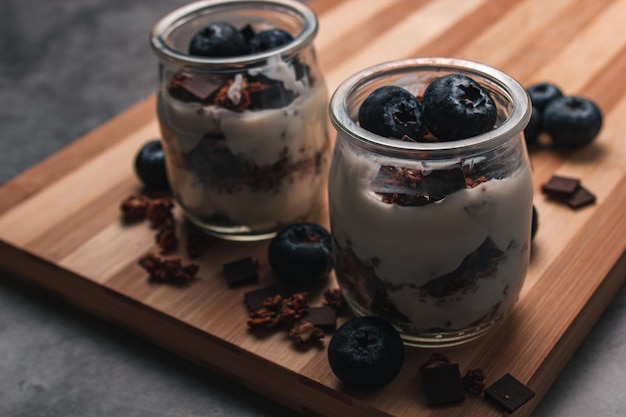 Yogur de desayuno saludable con bayas y muesli en frascos