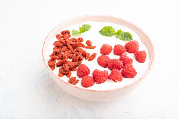 Yogur con frambuesa y bayas de goji en tazón de cerámica