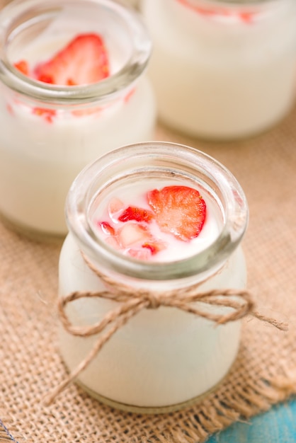 Yogur de fresa. Comida sana con desayuno de yogur y fresas en la mesa.