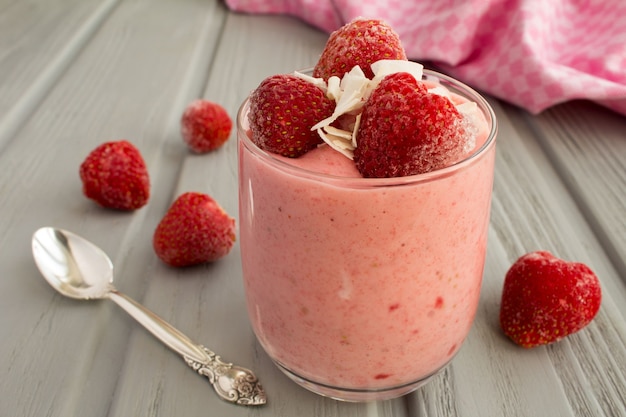 Yogur con fresa congelada en el fondo de madera gris