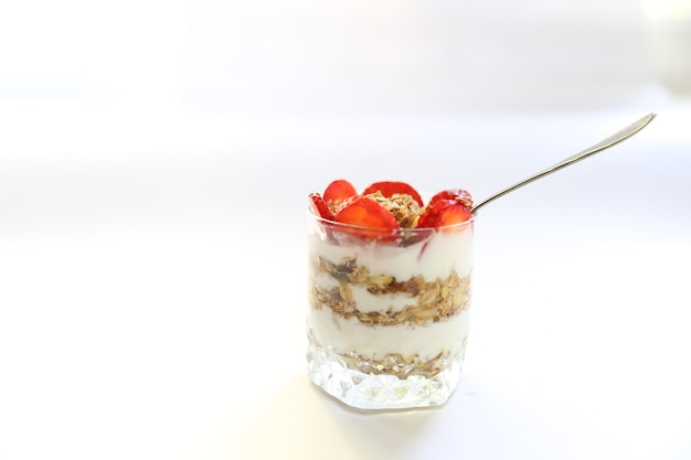 Yogur de fresa con granola y rodajas de fresa