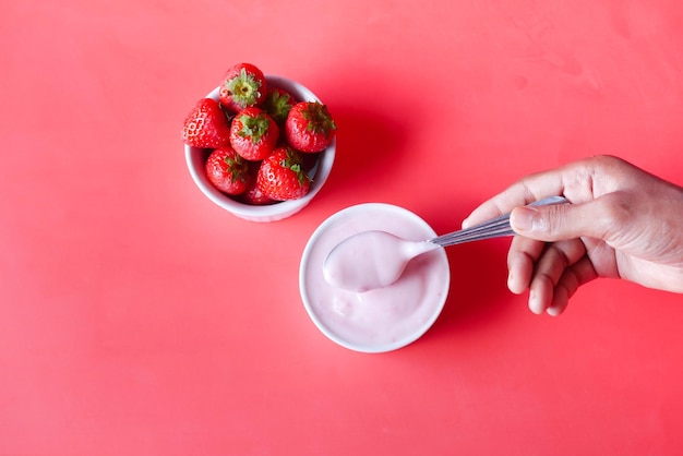 Yogur y fresa en un recipiente en blanco