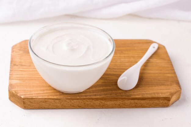 Yogur fresco en una tabla para cortar madera