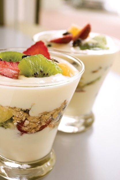 yogur con frutas y cereales en recipiente de vidrio