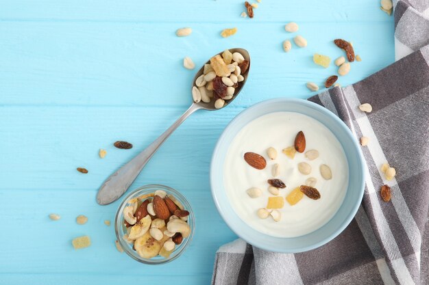 Yogur con frutas granola y nueces en la vista superior de la mesa