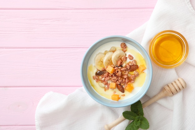 Foto yogur con frutas granola y nueces en la vista superior de la mesa