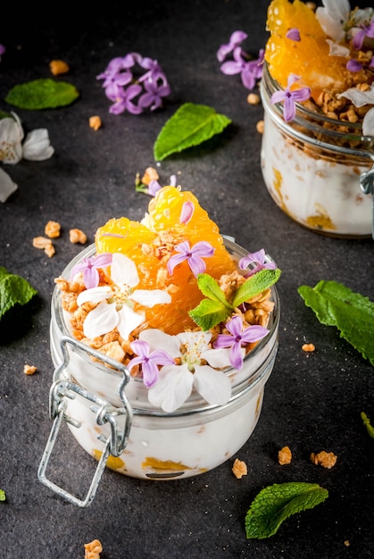 Yogur con granola, naranja, menta y flores comestibles.