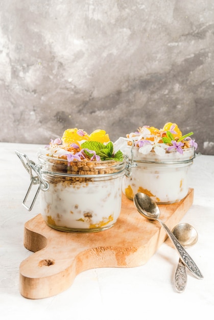 Yogur con granola, naranja, menta y flores comestibles.