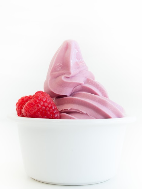 Yogur helado suave en taza sobre fondo blanco.