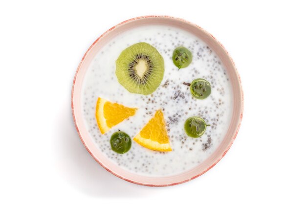 Yogur con kiwi, grosella, chía en cuenco de cerámica aislado sobre fondo blanco. vista superior, de cerca.