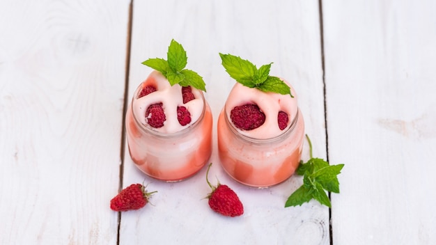 Yogur matutino en la naturaleza con frutos rojos y menta.