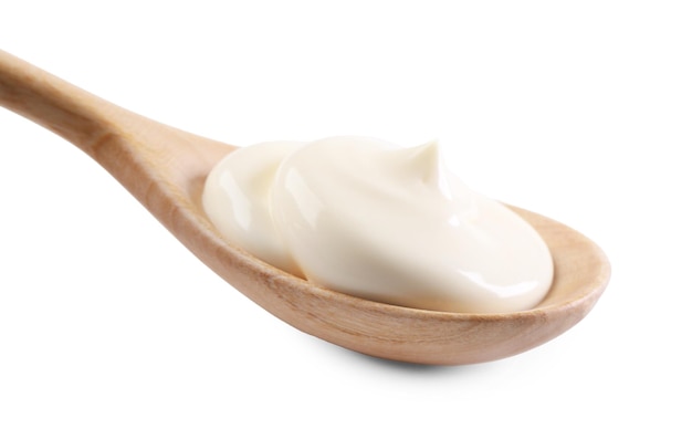 Yogur natural en cuchara de madera aislado en blanco