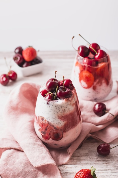 Foto yogur parfaits con cerezas y fresas en una mesa de madera