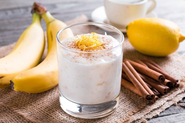 Yogur de plátano y plátanos frescos sobre un fondo de madera