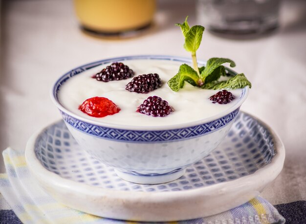 Yogur en un tazón y bayas frescas en la parte superior, en una servilleta blanca