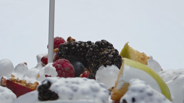 Yogur vertiendo muesli de frutas en primer plano de cámara super lenta Alimentos saludables de nutrientes