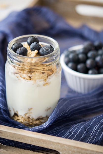 Yogurt con arándanos en una bandeja de madera