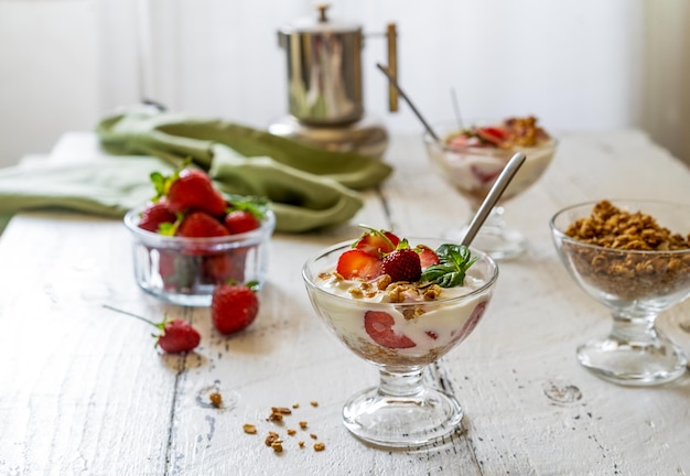 Yogurt con compota de fresa y granola con frutas frescas en copas de postre Desayuno saludable