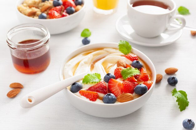 Yogurt con fresas, arándanos, miel, almendras y quinua para el desayuno