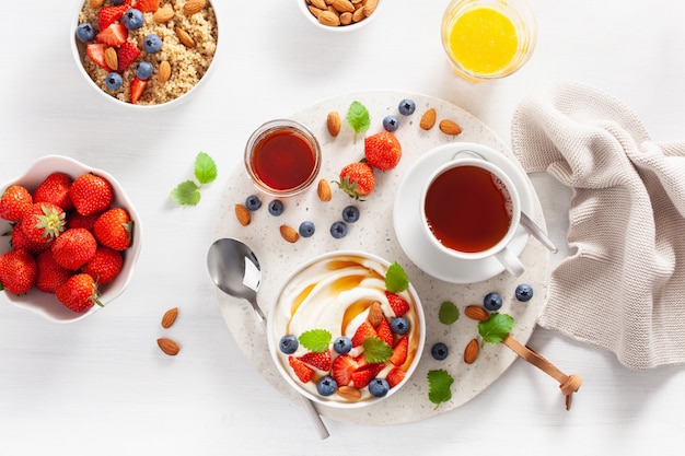 Yogurt con fresas, arándanos, miel, almendras y quinua para el desayuno