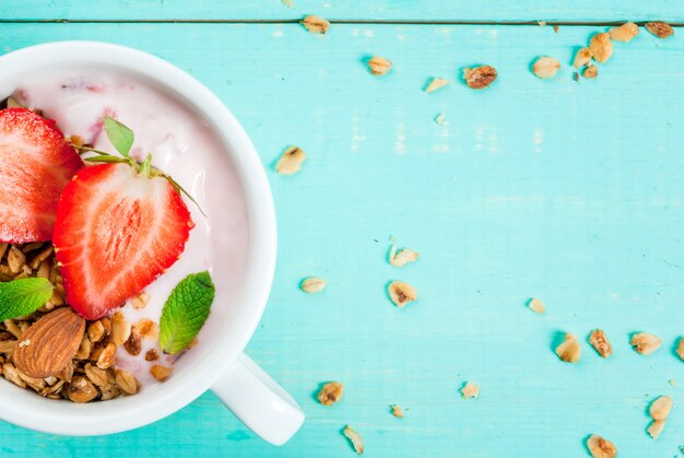 Yogurt con granola, nueces y fresas frescas