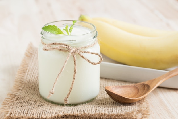 Yogurt en tarro de cristal en la mesa de madera