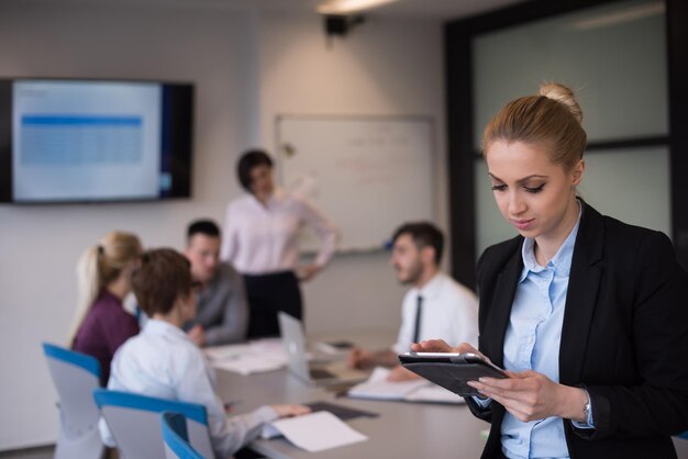 yonug blonde Geschäftsfrau bei der Arbeit an einem Tablet-Computer im modernen Start-Business-Büro-Interieur