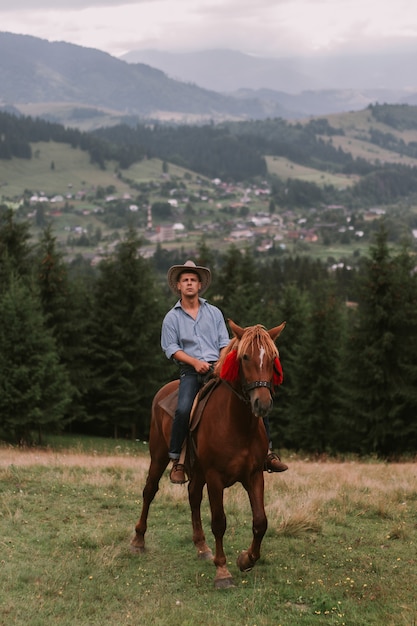 Youg man montando a caballo en las montañas