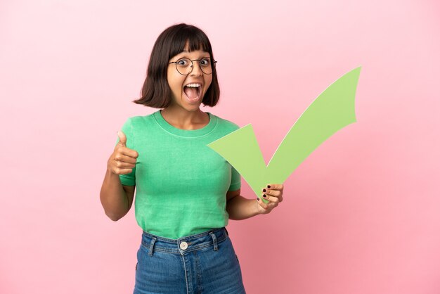 Youing mujer sosteniendo un icono de cheque y apuntando hacia arriba