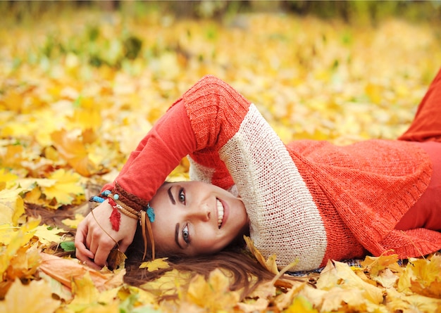 Yound linda mujer descansar en el parque otoño