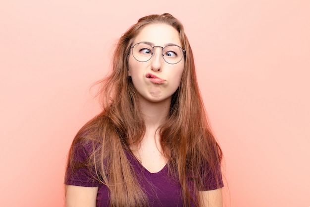 Yound mujer rubia que parece tonta y divertida con una expresión tonta con los ojos cruzados, bromeando y jugando