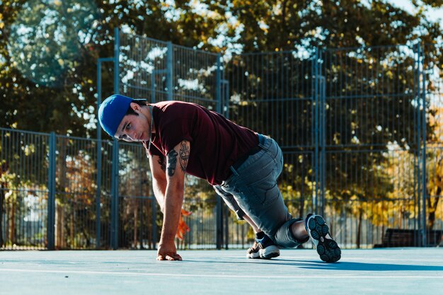 Foto young b boy bailando y posando en la cancha de baloncesto