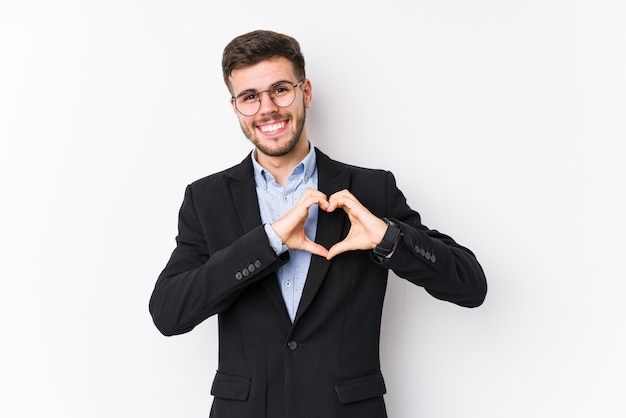 Young business man posing Homem de negócios jovem sorrindo e mostrando uma forma de coração com as mãos