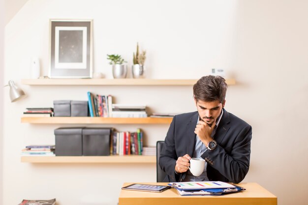 Young freelancer analiza el informe estadístico en el escritorio