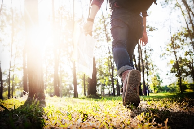 Young Man Traveller mit Rucksack entspannenden Outdoor mit felsigen Berge auf Hintergrund Sommer Urlaub und Lifestyle Wandern Konzept