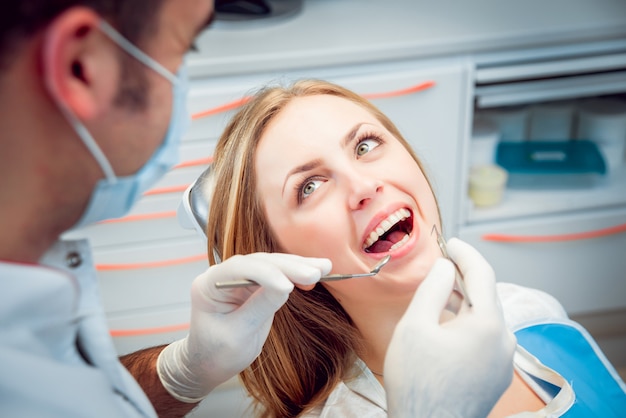 Young sonrió a la mujer en el consultorio dental