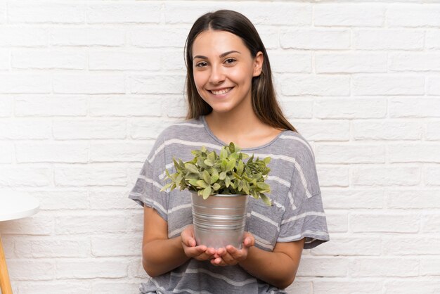 Younng mujer en una casa tomando una maceta