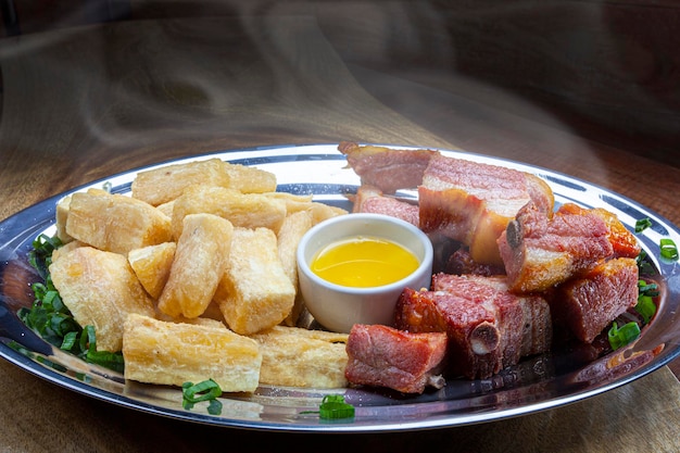 Yuca cocinada con mantequilla de botella y costillas de cerdo