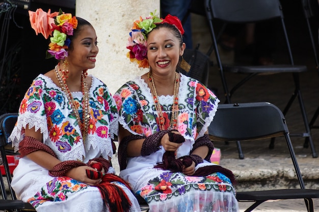 yucatecan Mädchen sprechen miteinander und warten darauf, dass er an der Reihe ist, um beim Stadtfestival aufzutreten.