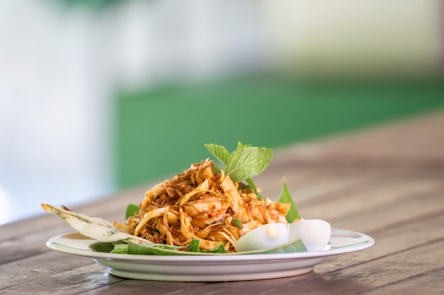 "Yum Hua Plee" es la ensalada picante de flor de plátano de la zona norte tradicional local de Tailandia que se dispara en la mesa de madera.