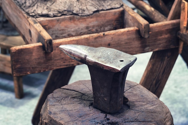 Yunque sobre un tocón de madera en una fragua de estilo rústico antiguo