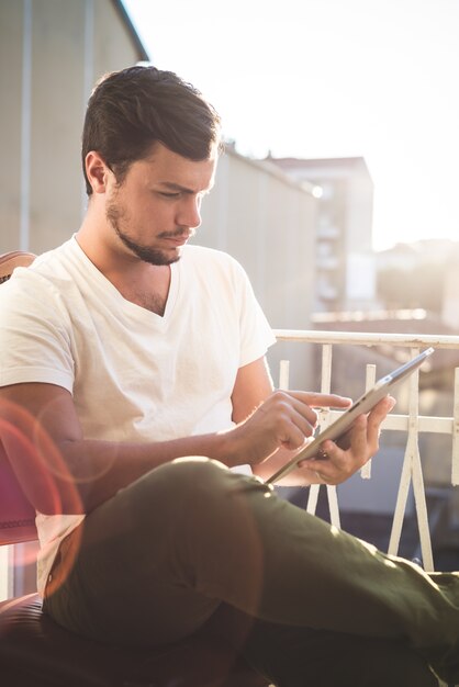 Foto yuong elegante hipster hombre usando tableta