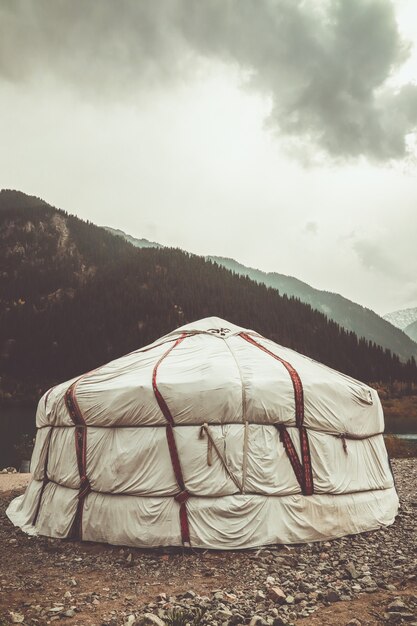 Yurta en el lago en las montañas de Kazajstán. Picos de las montañas nevadas.