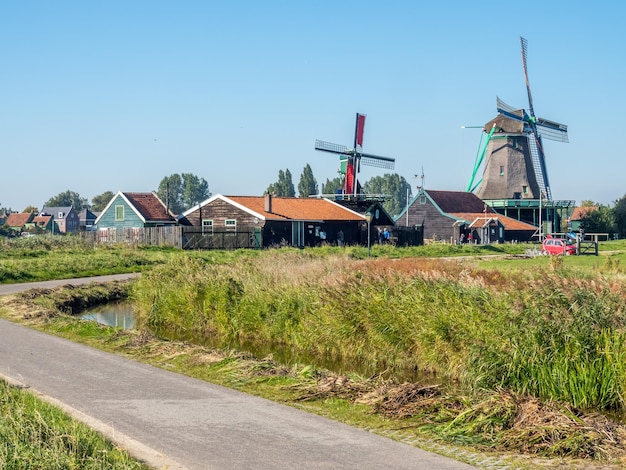 ZAAN SCHANS - 2 DE OCTUBRE: Escena de la ciudad y molinoes de viento clásicos históricos con turistas en Zaan Schans bajo un cielo azul, Países Bajos, el 2 de octubre de 2015.