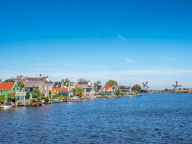 Zaan Schans es una atracción popular en los Países Bajos, tiene una colección de molinos de viento y casas históricas bien conservadas, esta vista desde el puente bajo el cielo azul